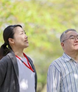職員と入居者が屋外で一緒に過ごしている様子